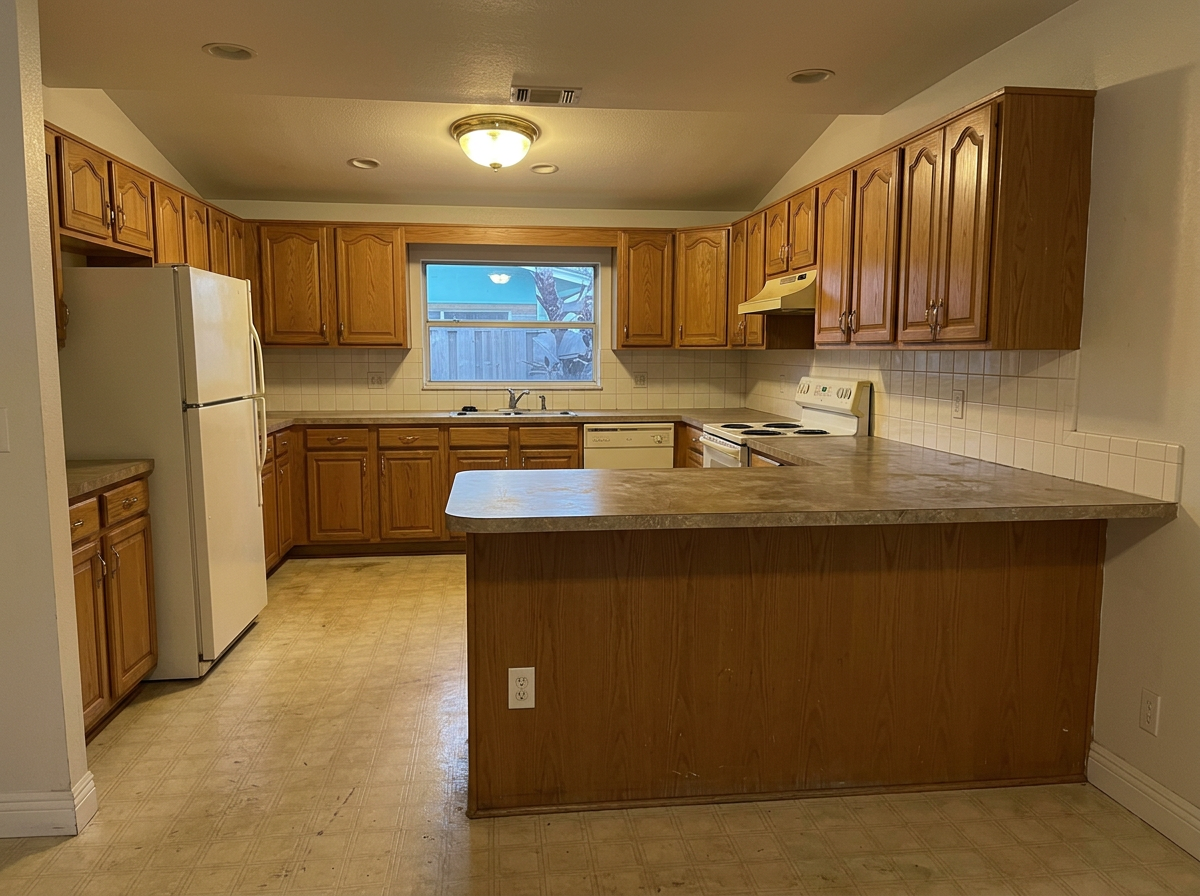 Same kitchen before — oak cabinets and laminate counter